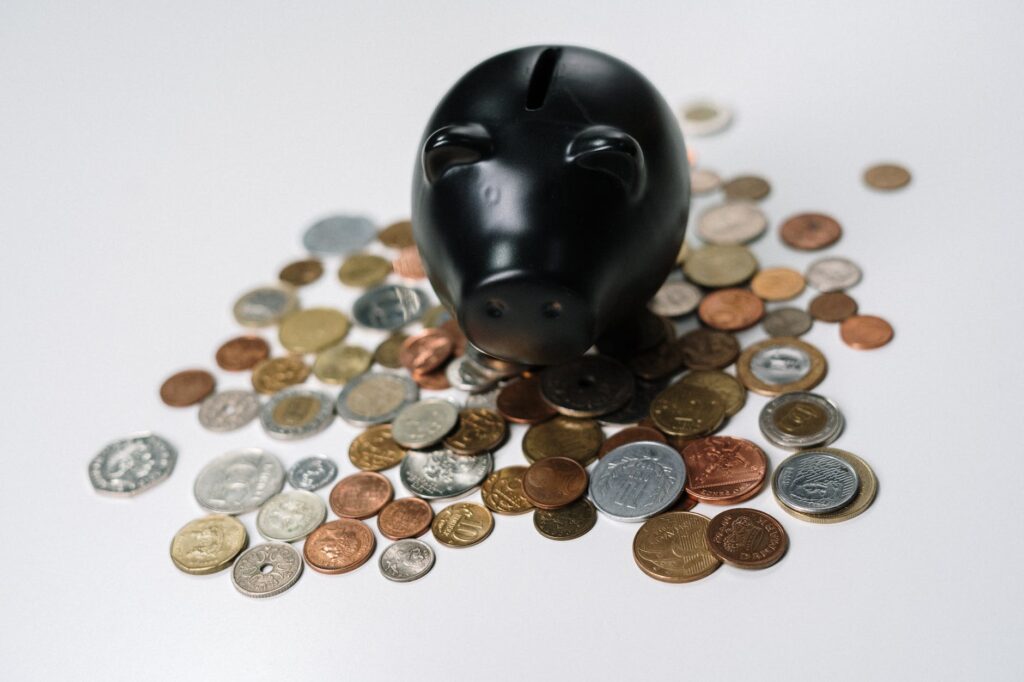 a black piggy bank in the middle of coins